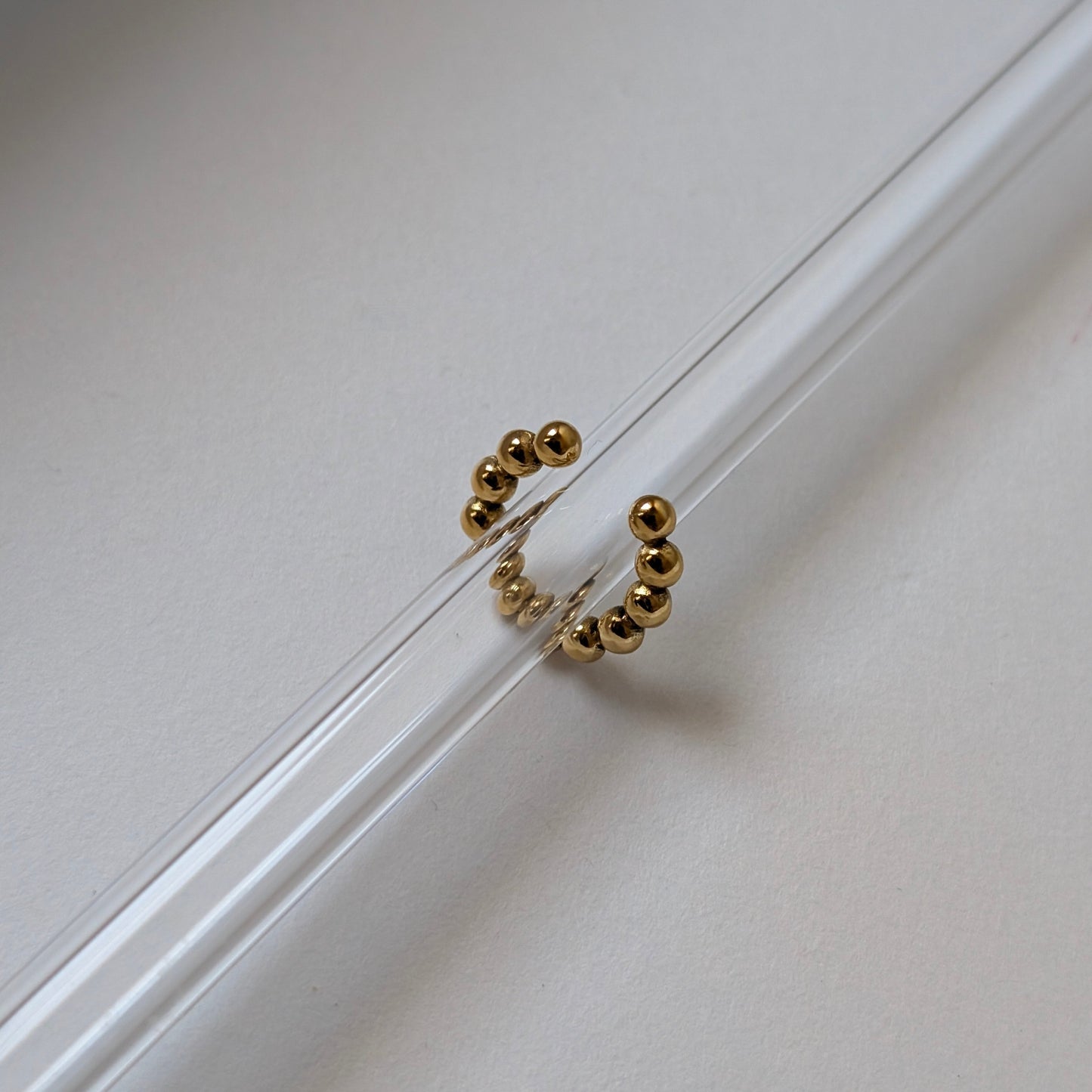 Gold beaded ear cuff beside ruler showing 1.54 cm diameter mini size reference.