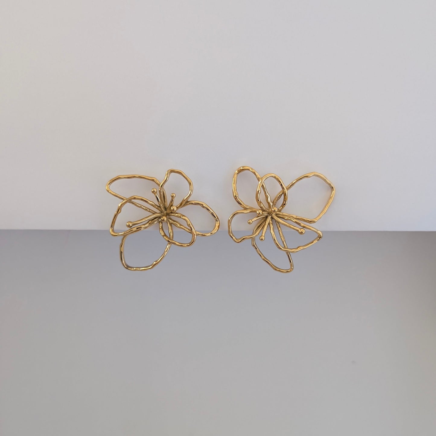 Alternate front angle highlighting textured orchid petals on gold statement earrings, lightweight 12.9 g pair