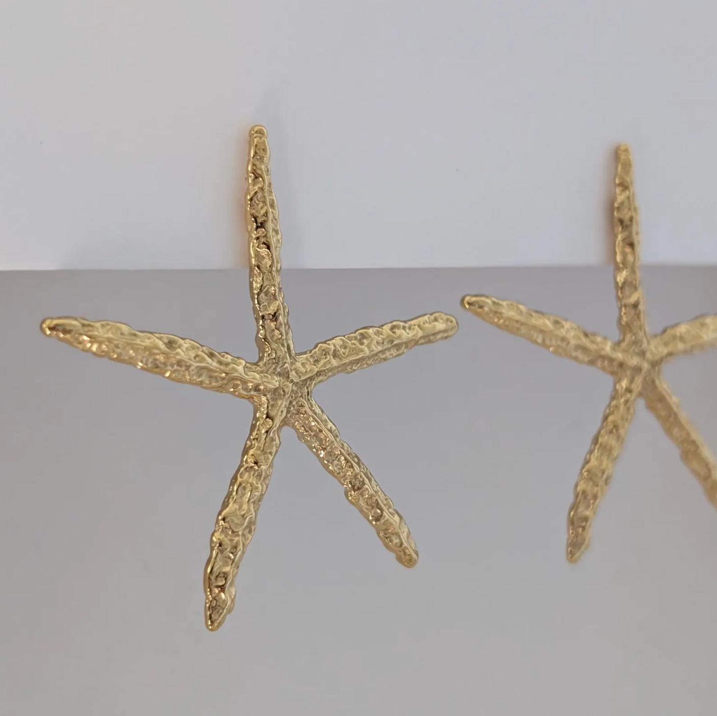Side angle showing sculpted starfish detail and 3.3 × 5.4 cm size of gold statement earrings.