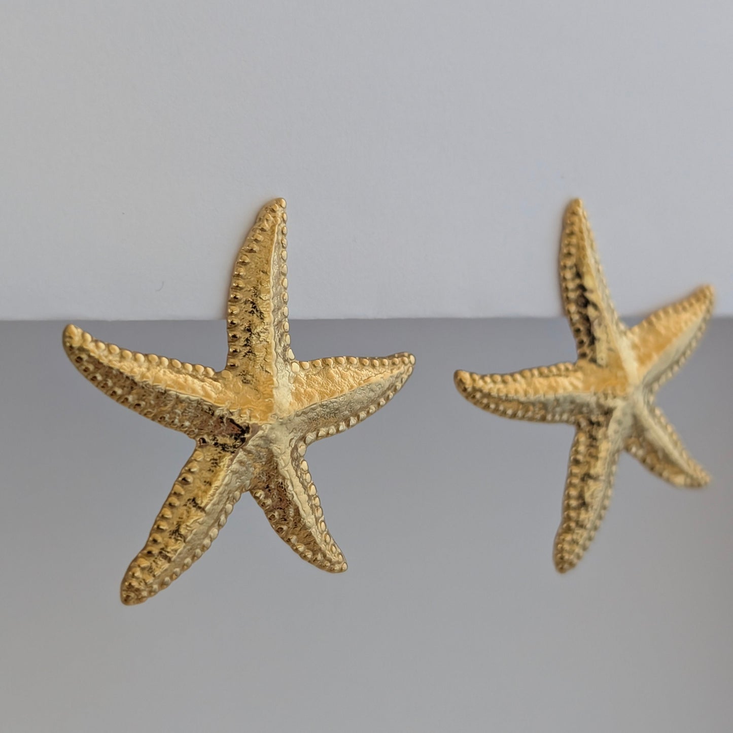 Side angle showing raised starfish arms and hypoallergenic stainless‑steel post.