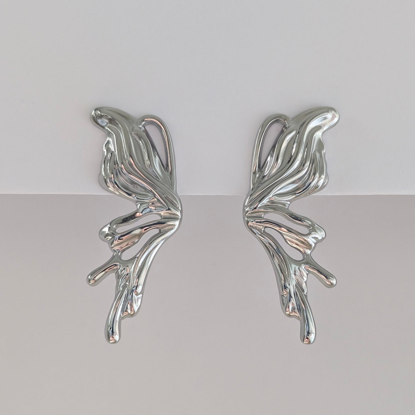 Alternate front angle showing curved silhouette of silver sculptural statement earrings, lightweight 9.3 g pair.