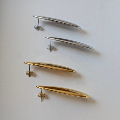Side‑angle comparison of gold and silver teardrop statement earrings—Raya collection, 4.53 cm drop, high‑shine finish.