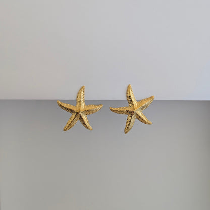 Alternate front angle of gold starfish stud earrings—18k gold plated, polished finish, sculpted texture.