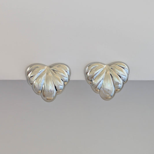 Front view of silver palm leaf statement earrings—316L steel base, hypoallergenic and tarnish resistant.