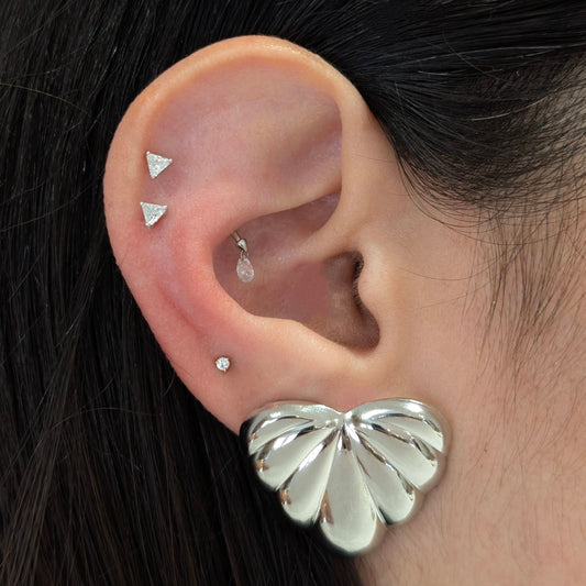 Styled stack of Amore silver palm leaf earrings with other hoops—tropical resort jewelry vibe